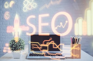 Bilgisayar ve seo çizim hologramı olan bir masanın çifte görüntüsü. Arama optimizasyon kavramı.