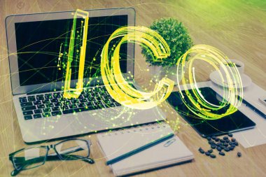 Engelleme zinciri ve kripto ekonomi temalı hologram ve bilgisayar geçmişi olan bir masa. Bitcoin kripto para kavramı.