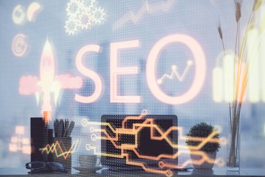 Bilgisayar ve seo çizim hologramı olan bir masanın çifte görüntüsü. Arama optimizasyon kavramı.