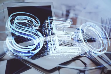 Bilgisayar ve seo çizim hologramı olan bir masanın çifte görüntüsü. Arama optimizasyon kavramı.