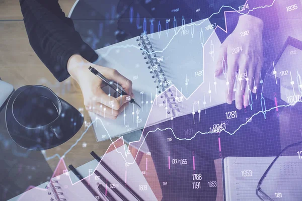 Holograma gráfico de divisas en la mano tomando notas de fondo. Concepto de análisis. Exposición múltiple —  Fotos de Stock