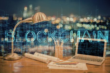 Engelleme zinciri ve kripto ekonomi temalı hologram ve bilgisayar geçmişi olan bir masa. Bitcoin kripto para kavramı.