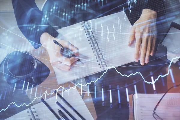 Holograma gráfico de divisas en la mano tomando notas de fondo. Concepto de análisis. Exposición múltiple —  Fotos de Stock