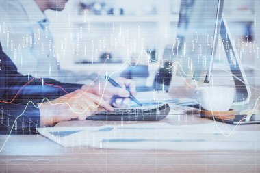 Arka planda ofiste bilgisayarda çalışan işadamı ile Forex grafiği. Sert çalışma kavramı. Closeup. Çoklu pozlama.