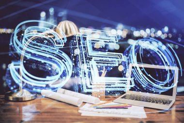 Bilgisayar ve seo çizim hologramı olan bir masanın çifte görüntüsü. Arama optimizasyon kavramı.