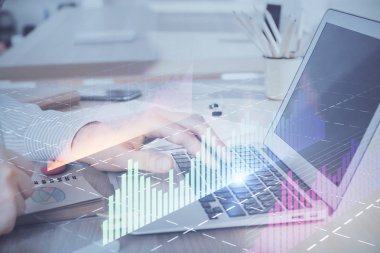 Arka planda dizüstü bilgisayar üzerinde çalışan adam ile borsa grafiği çoklu pozlama. Finansal analiz kavramı.