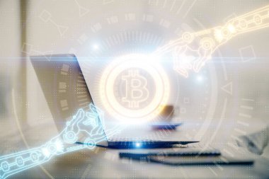 Engelleme zinciri ve kripto ekonomi temalı hologram ve bilgisayar geçmişi olan bir masa. Bitcoin kripto para kavramı.