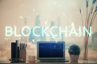 Engelleme zinciri ve kripto ekonomi temalı hologram ve bilgisayar geçmişi olan bir masa. Bitcoin kripto para kavramı.