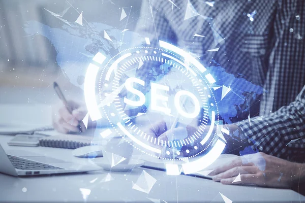 Arka planda bilgisayarla çalışan bir adamla iki kez simgeye maruz kalıyoruz. Arama motoru optimizasyonu kavramı.