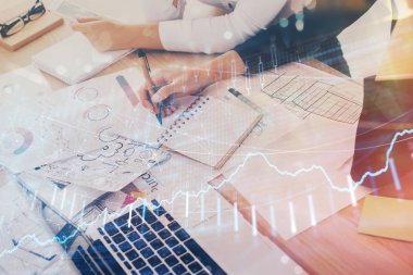 Bir kadın eller Not defteri hisse senedi piyasası hakkında bilgi yazma. Ön Forex grafik hologramlar. Araştırma kavramı. Çift Pozlama