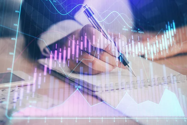 Una mujer escribe información sobre el mercado de valores en bloc de notas. Hologramas gráfico de divisas en frente. Concepto de investigación. Exposición múltiple —  Fotos de Stock