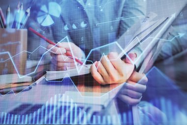 Bir kadın eller Not defteri hisse senedi piyasası hakkında bilgi yazma. Ön Forex grafik hologramlar. Araştırma kavramı. Çoklu pozlama