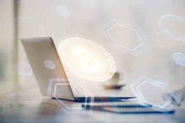Engelleme zinciri ve kripto ekonomi temalı hologram ve bilgisayar geçmişi olan bir masa. Bitcoin kripto para kavramı.