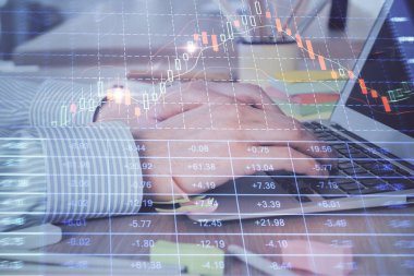 Arka planda dizüstü bilgisayar üzerinde çalışan adam ile borsa grafiği çoklu pozlama. Finansal analiz kavramı.