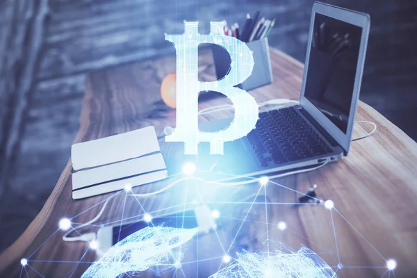 Engelleme zinciri ve kripto ekonomi temalı hologram ve bilgisayar geçmişi olan bir masa. Bitcoin kripto para kavramı.
