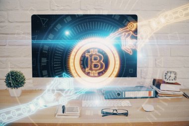 Engelleme zinciri ve kripto ekonomi temalı hologram ve bilgisayar geçmişi olan bir masa. Bitcoin kripto para kavramı.