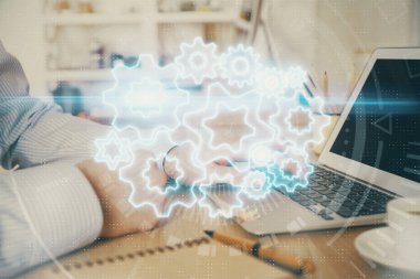 Arka planda dizüstü bilgisayarda çalışan iş adamlarının çoklu pozları. Uluslararası iş hologramı önde. Başarı kavramı.