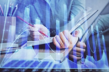 Bir kadın eller Not defteri hisse senedi piyasası hakkında bilgi yazma. Ön Forex grafik hologramlar. Araştırma kavramı. Çoklu pozlama