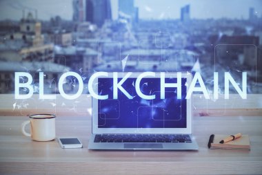 Engelleme zinciri ve kripto ekonomi temalı hologram ve bilgisayar geçmişi olan bir masa. Bitcoin kripto para kavramı.