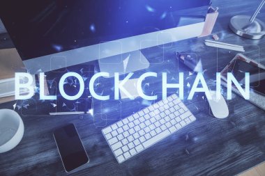 Engelleme zinciri ve kripto ekonomi temalı hologram ve bilgisayar geçmişi olan bir masa. Bitcoin kripto para kavramı.