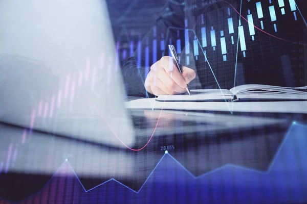 Double exposure of businessman with laptop and stock market forex chart.