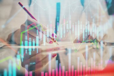 Bir kadın eller Not defteri hisse senedi piyasası hakkında bilgi yazma. Ön Forex grafik hologramlar. Araştırma konsepti.