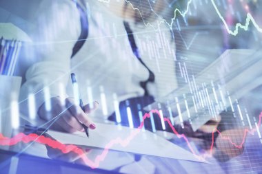 Bir kadın eller Not defteri hisse senedi piyasası hakkında bilgi yazma. Ön Forex grafik hologramlar. Araştırma konsepti.