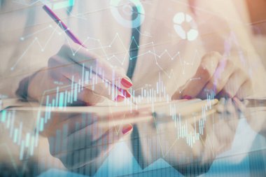 Bir kadın eller Not defteri hisse senedi piyasası hakkında bilgi yazma. Ön Forex grafik hologramlar. Araştırma konsepti.