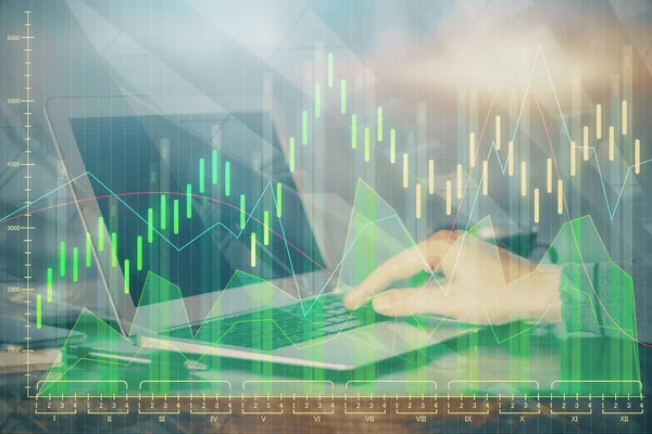 Double exposure of businessmans hands with laptop and stock market graph background. Concept of research and trading.