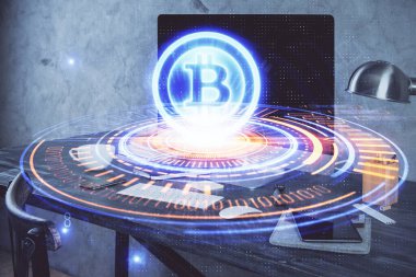 Engelleme zinciri ve kripto ekonomi temalı hologram ve bilgisayar geçmişi olan bir masa. Bitcoin kripto para kavramı.