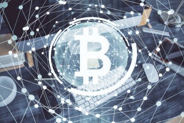 Engelleme zinciri ve kripto ekonomi temalı hologram ve bilgisayar geçmişi olan bir masa. Bitcoin kripto para kavramı.