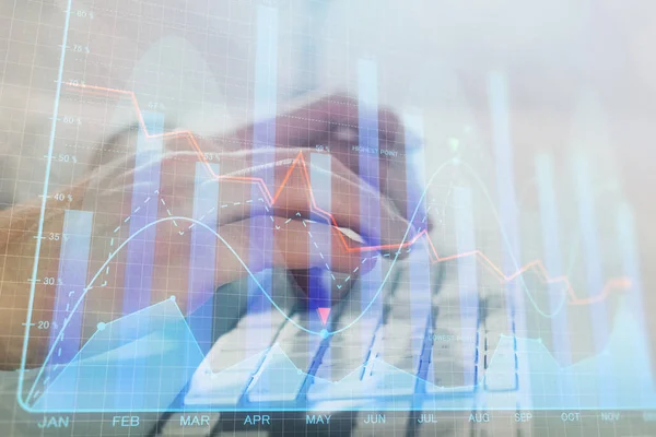 Doppelbelichtung des Diagramms mit einem Mann, der auf dem Computer im Büro im Hintergrund tippt. Konzept der harten Arbeit. Nahaufnahme. — Stockfoto