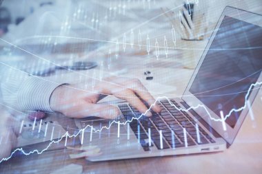 Arka planda dizüstü bilgisayar üzerinde çalışan adam ile borsa grafiği çoklu pozlama. Finansal analiz kavramı.