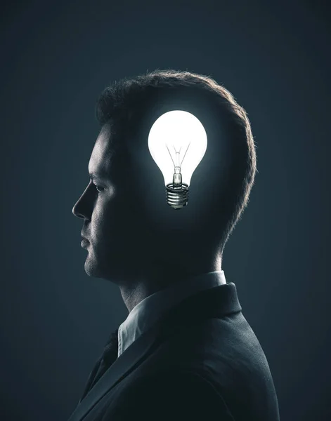 頭の中で電球を持ったビジネスマン — ストック写真