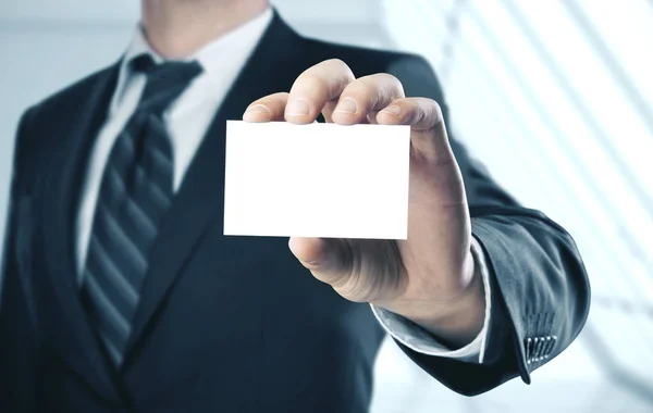 Empresário segurando um cartão comercial em branco — Fotografia de Stock