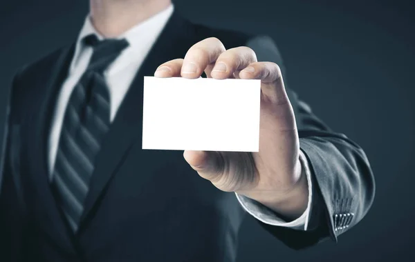 Empresário segurando um cartão comercial em branco — Fotografia de Stock