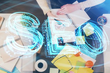 Kadın elinin SEO simgesiyle notlar alırken çoklu pozlanması. Arama motoru optimizasyonu kavramı