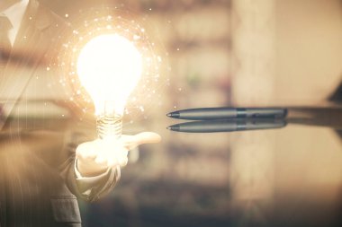 Ofisteki kahve fincanı arka planında ampul hologramına iki kez maruz kalmış. Fikir kavramı