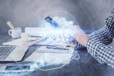 Erkeklerin el ele tutuşup dijital bir cihaz ve veri temalı hologram çizimi kullanırken çift pozlama. Teknoloji konsepti.