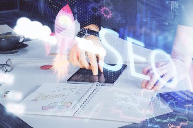 Erkeklerin el ele tutuşup dijital bir cihaz ve seo çizimi kullanırken birden fazla pozlama. arama optimizasyonu kavramı.