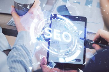 Erkeklerin el ele tutuşup dijital bir cihaz ve seo çizimi kullanırken birden fazla pozlama. arama optimizasyonu kavramı.