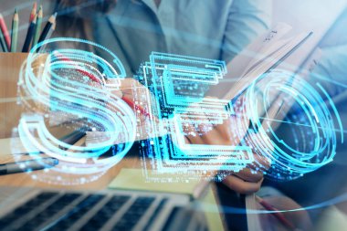 Kadın elinin SEO simgesiyle notlar alırken çoklu pozlanması. Arama motoru optimizasyonu kavramı