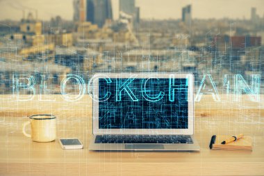 Engelleme zinciri ve kripto ekonomi temalı hologram ve bilgisayar geçmişi olan bir masa. Bitcoin kripto para kavramı.