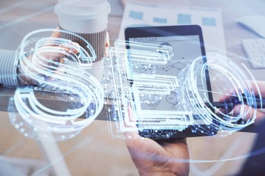 Erkeklerin el ele tutuşup dijital bir cihaz ve seo çizimi kullanırken birden fazla pozlama. arama optimizasyonu kavramı.