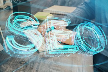 Arka planda bilgisayar üzerinde çalışan bir adamla birlikte çok sayıda simgeye maruz kalma. Arama motoru optimizasyonu kavramı.