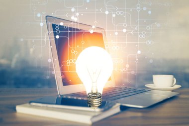 Bilgisayar ofisinde ampul simgesi hologramıyla birlikte. Çoklu maruz kalma. Fikir kavramı.