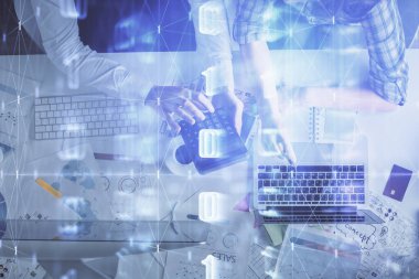 Kadın ve erkeğin birlikte çalışması ve veri temalı hologram çizimi. Bilgisayar arkaplanı. Üst Görünüm.