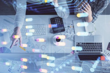 Kadın ve erkeğin birlikte çalışması ve veri temalı hologram çizimi. Bilgisayar arkaplanı. Üst Görünüm.