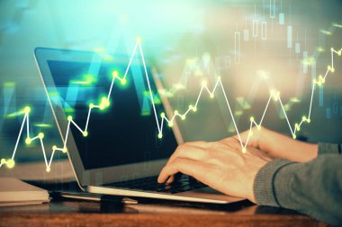 Arka planda dizüstü bilgisayar üzerinde çalışan adam ile borsa grafiği çoklu pozlama. Finansal analiz kavramı.