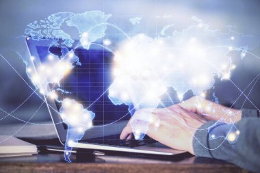 Arka planda dizüstü bilgisayarda çalışan iş adamlarının çoklu pozları. Uluslararası iş hologramı önde. Başarı kavramı.